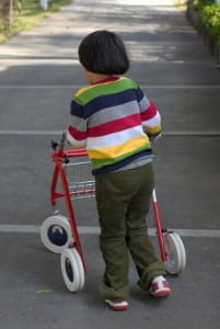 Little girl walking with some assistance