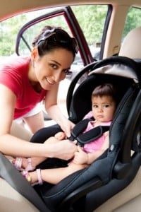 mom installing baby in car seat