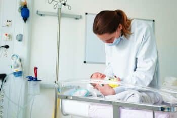 nurse holding premature baby in NICU