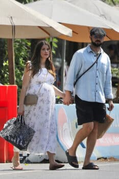 ashley green in a shite floral dress holds her hsuband's hand as they leave lunch in la