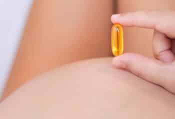 A pregnant mom take her vitamins. Omega and fish oil supplements