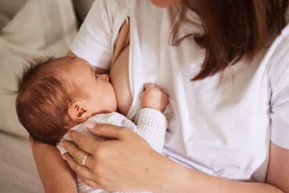 Mother breastfeeding her newborn baby boy