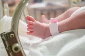 Newborn girl baby inside incubator in hospital