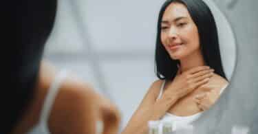 woman applying cream to her neck