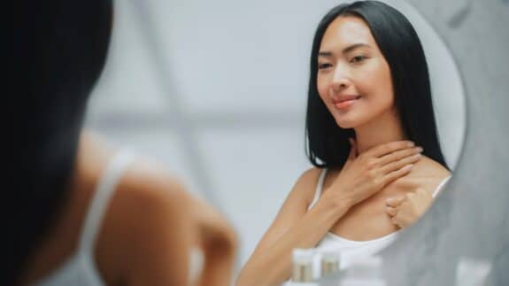 woman applying cream to her neck