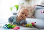 Cute baby boy playing with toys in a living room