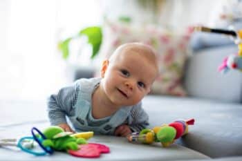 Cute baby boy playing with toys in a living room