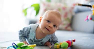 Cute baby boy playing with toys in a living room