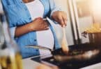 Pregnant, cooking and woman in kitchen in home