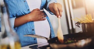 Pregnant, cooking and woman in kitchen in home