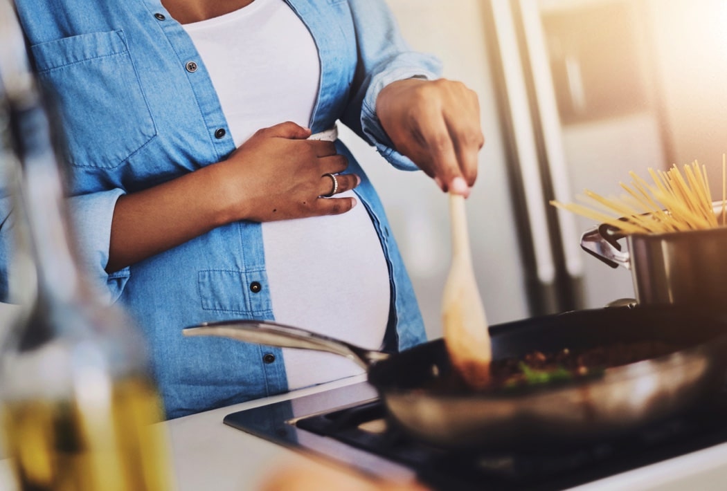 Pregnant, cooking and woman in kitchen in home