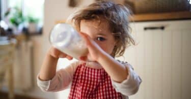 toddler drinking milk from a bottle