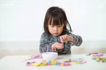 child playing with beads