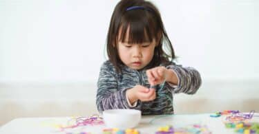 child playing with beads