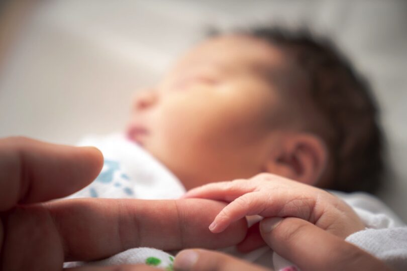 newborn infant baby girl in a blanket swaddle