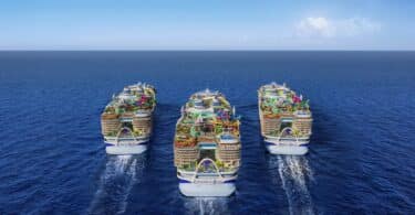 Three Icon class cruise ships sailing away in the ocean