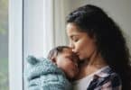 young mother giving her baby a kiss at home